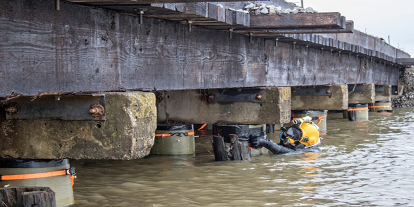 Diver inspecting bridge pier structural steel