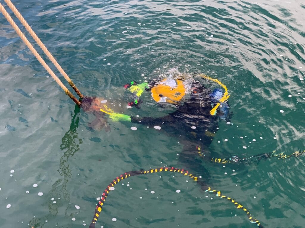 Commercial diver with surface-supplied helmet conducting salvage and recovery diving operation